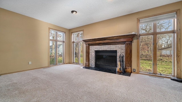2239 Pine Bluff Dr, Dixon, IL 61021 - unfurnished living room with carpet floors, plenty of natural light, a brick fireplace, and a textured ceiling