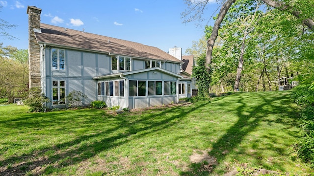 2239 Pine Bluff Dr, Dixon, IL 61021 - back of property featuring a chimney, a sunroom, and a lawn