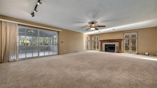 2239 Pine Bluff Dr, Dixon, IL 61021 - unfurnished living room featuring ceiling fan, carpet flooring, a fireplace, a textured ceiling, and track lighting