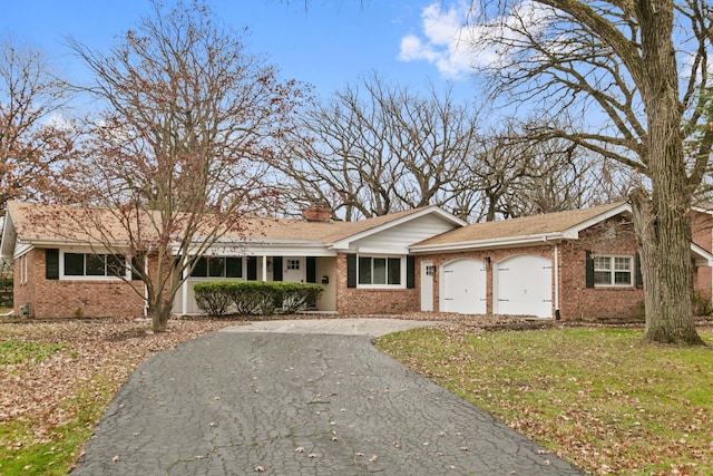 ranch-style house featuring a front yard and a garage