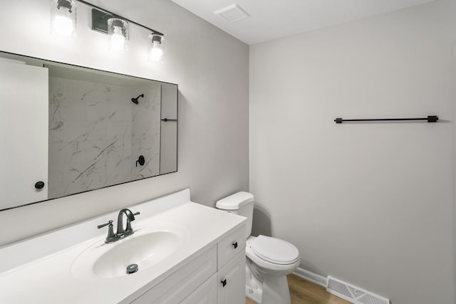 bathroom with vanity, toilet, and wood-type flooring