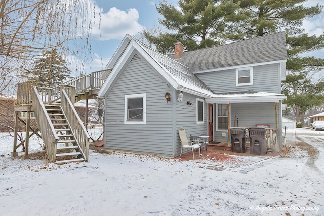 view of snow covered rear of property