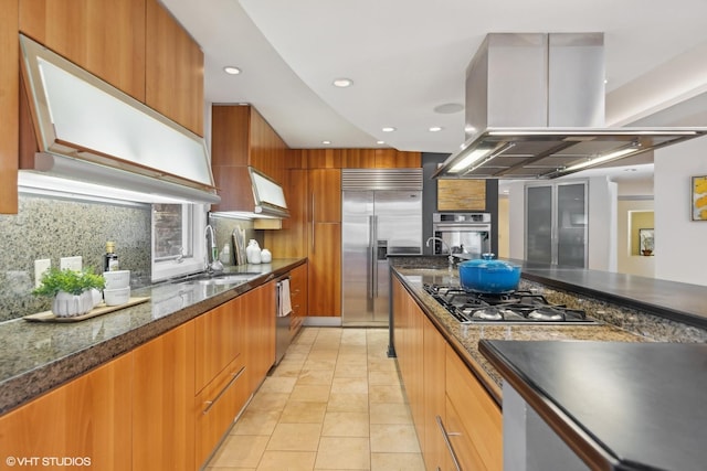 kitchen featuring sink, light tile patterned floors, tasteful backsplash, island range hood, and stainless steel appliances