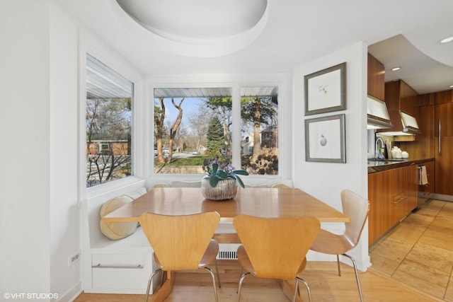 dining room featuring a raised ceiling and sink