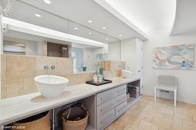 bathroom featuring vanity, a shower, and backsplash