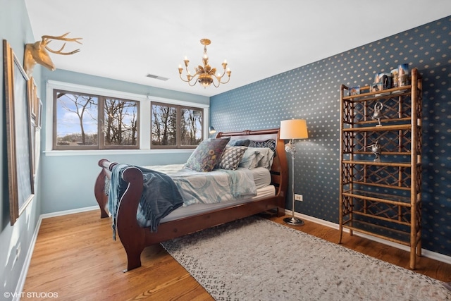 bedroom featuring hardwood / wood-style floors and an inviting chandelier