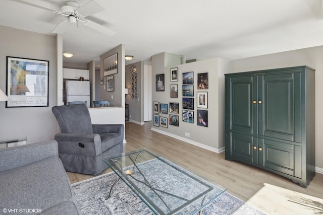 living room with light hardwood / wood-style flooring and ceiling fan