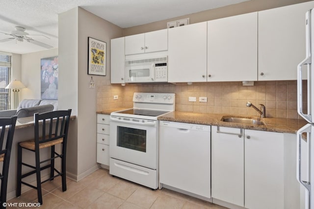 kitchen with tasteful backsplash, white cabinetry, sink, and white appliances