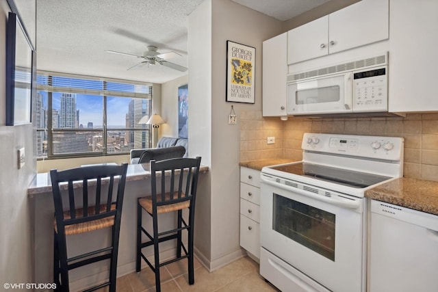 kitchen featuring white cabinets, a textured ceiling, white appliances, and backsplash