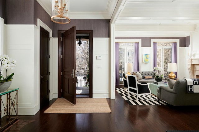 entrance foyer featuring wallpapered walls, wood finished floors, and crown molding