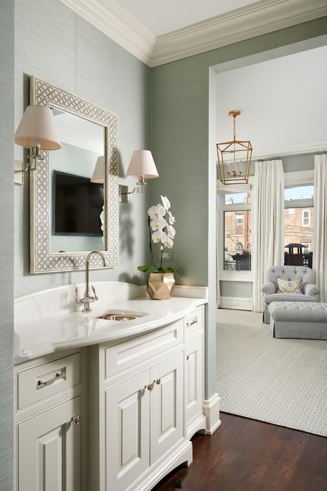 bathroom featuring vanity, ornamental molding, a notable chandelier, and wood finished floors