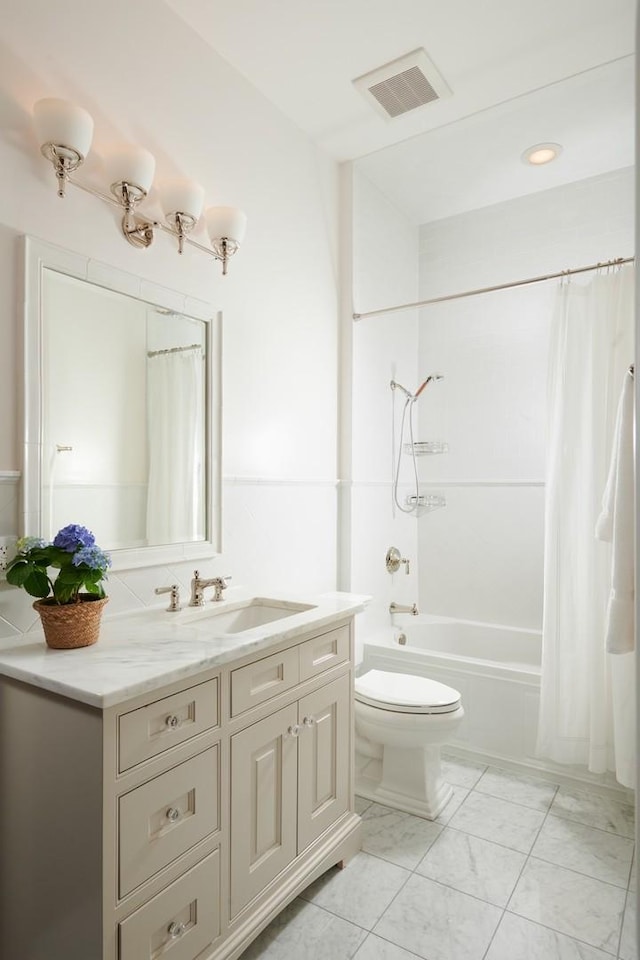 bathroom featuring shower / tub combo, toilet, marble finish floor, visible vents, and vanity