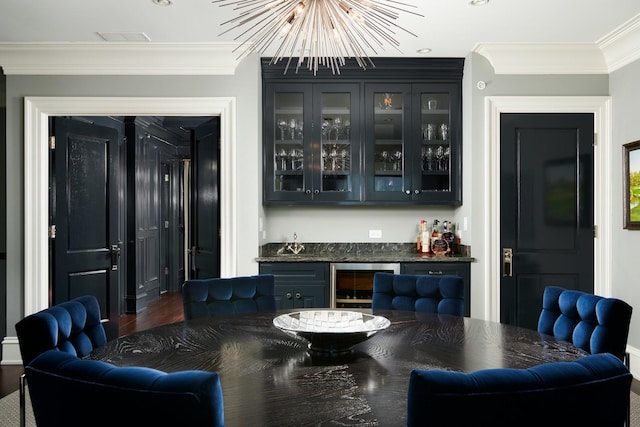 bar with wine cooler, ornamental molding, a chandelier, and a dry bar