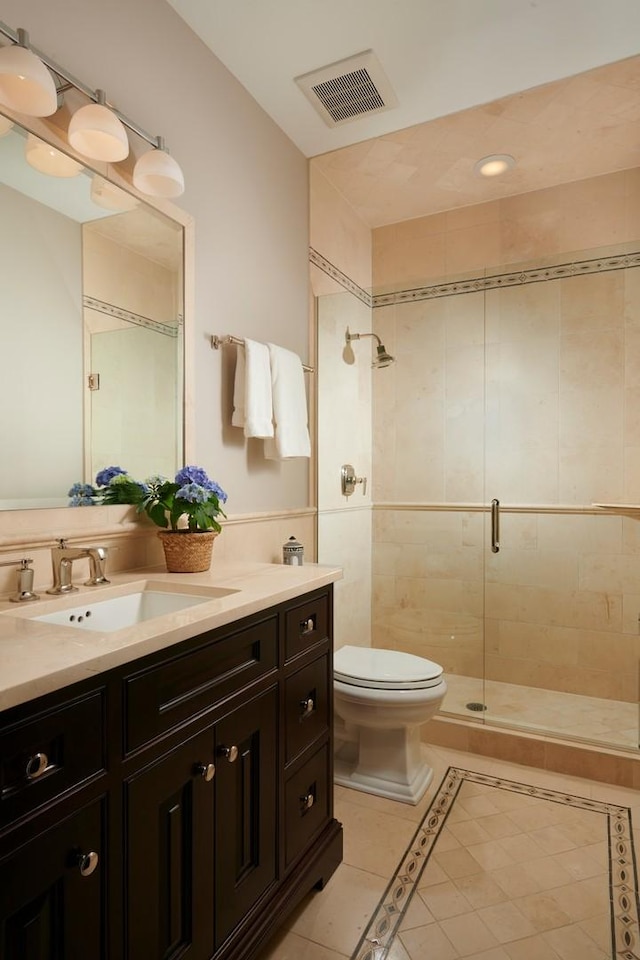 bathroom with a stall shower, toilet, visible vents, tile patterned flooring, and vanity