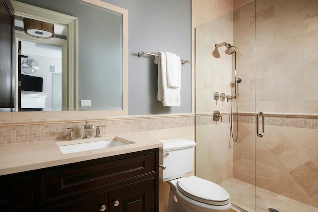 bathroom with vanity, toilet, a stall shower, and backsplash