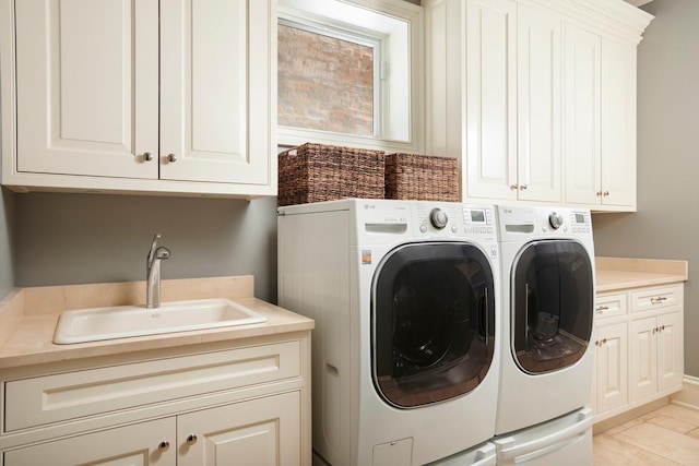 clothes washing area featuring a sink, cabinet space, and washer and dryer