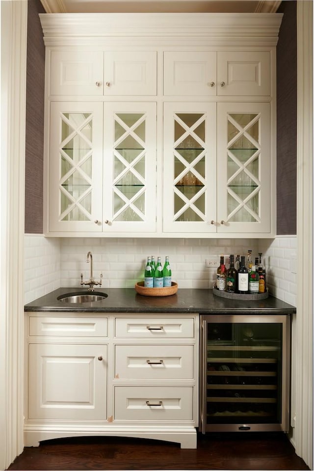 bar with indoor wet bar, a sink, and wine cooler