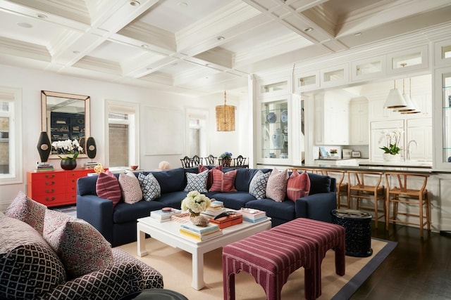 living area with coffered ceiling, ornamental molding, dark wood-style floors, and beam ceiling