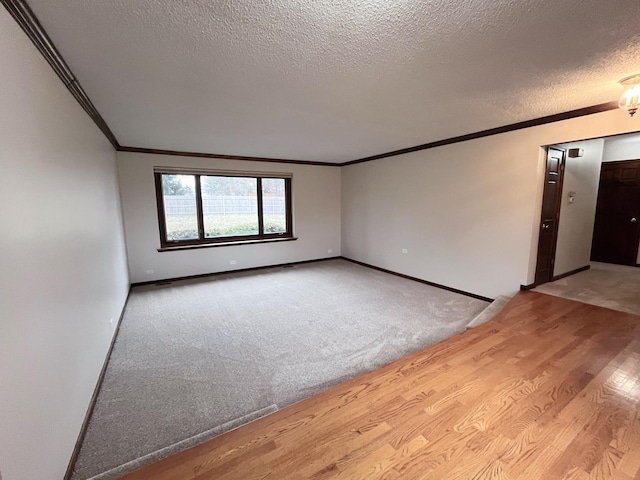 unfurnished room with crown molding, light wood-type flooring, and a textured ceiling