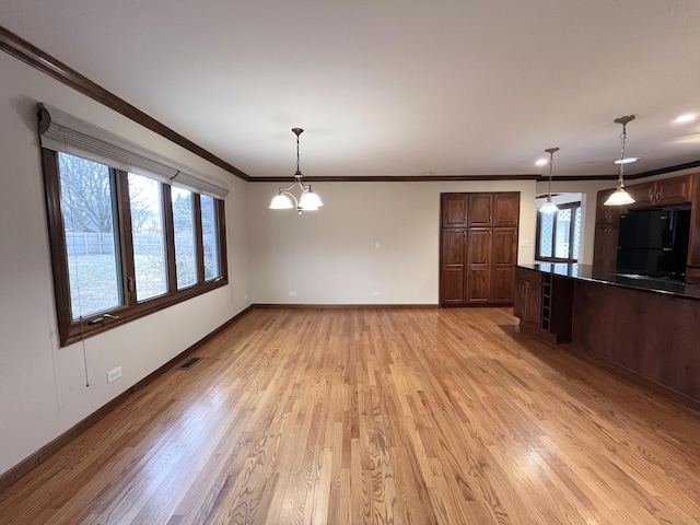 interior space with ceiling fan with notable chandelier, ornamental molding, and light hardwood / wood-style flooring