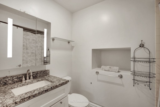 bathroom featuring vanity, toilet, and walk in shower