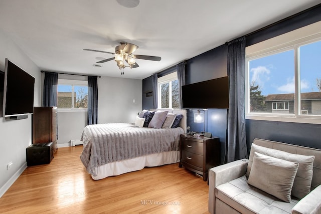 bedroom with light hardwood / wood-style floors, multiple windows, and ceiling fan