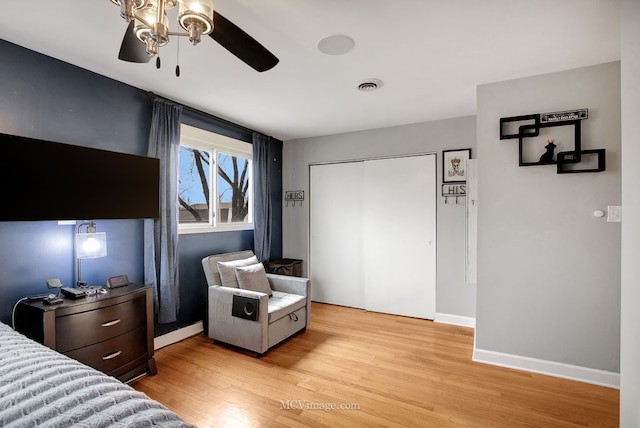 bedroom with ceiling fan, a closet, and light hardwood / wood-style flooring