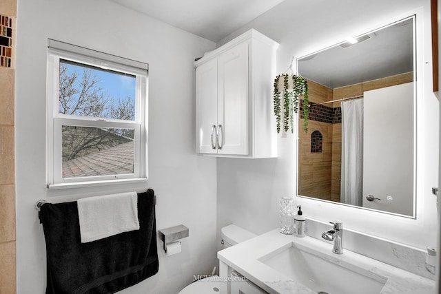 bathroom with a shower with curtain, vanity, and toilet