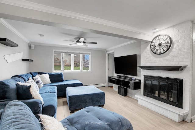 living room featuring light wood-type flooring, ornamental molding, ceiling fan, a baseboard radiator, and a fireplace