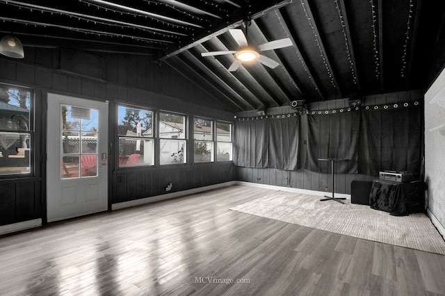 empty room featuring hardwood / wood-style flooring, vaulted ceiling, and ceiling fan