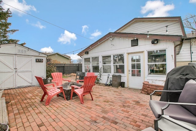 view of patio featuring a storage unit and an outdoor fire pit