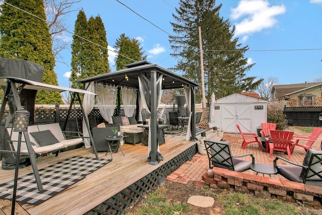 wooden deck featuring a gazebo, a shed, and an outdoor fire pit