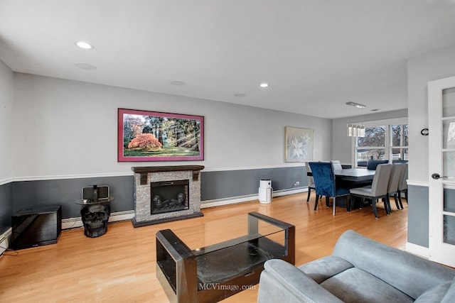 living room with wood-type flooring, a fireplace, and a baseboard radiator