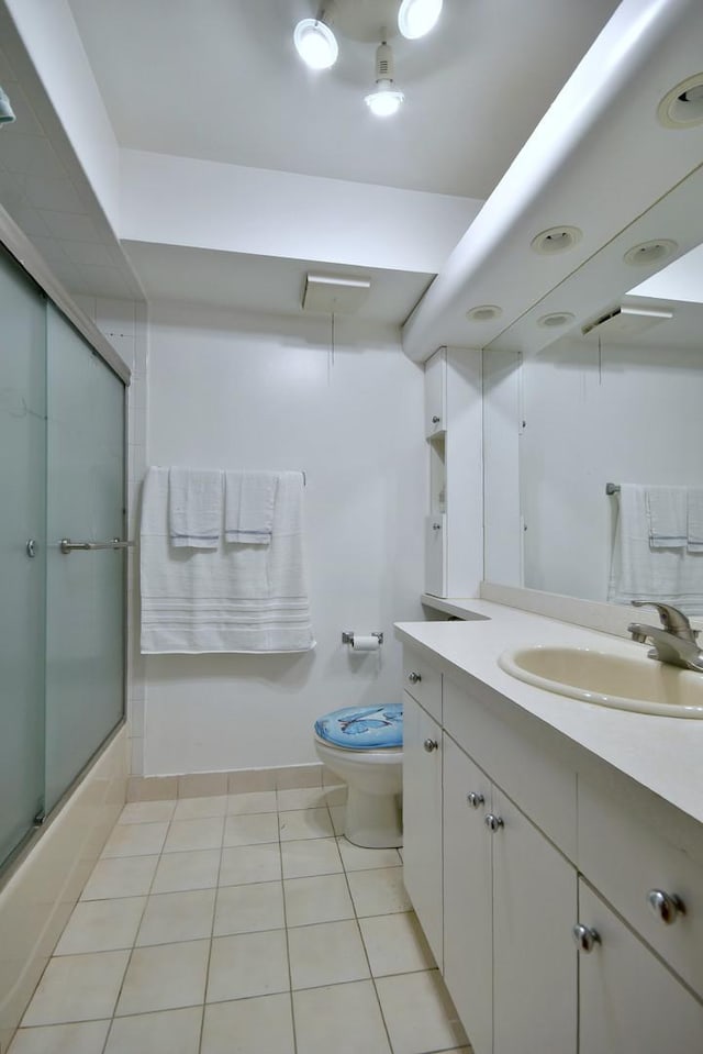 full bathroom with tile patterned floors, vanity, toilet, and shower / bath combination with glass door