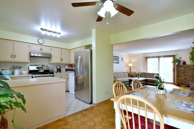 kitchen featuring tasteful backsplash, ceiling fan, light parquet flooring, and stainless steel appliances