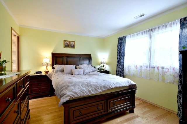 bedroom featuring crown molding and light hardwood / wood-style floors