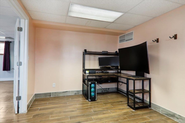 office space with a paneled ceiling and wood-type flooring