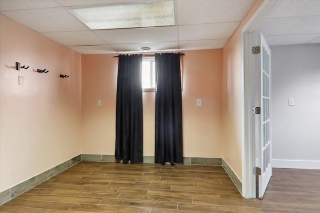 unfurnished room featuring hardwood / wood-style floors and a drop ceiling