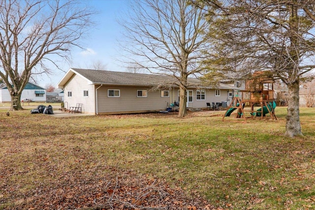 back of property with a playground and a lawn