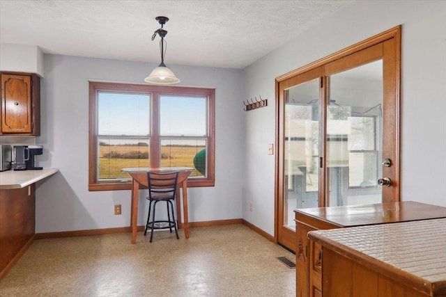 kitchen with tile countertops, pendant lighting, and a textured ceiling