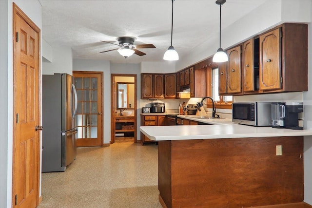 kitchen featuring sink, hanging light fixtures, ceiling fan, kitchen peninsula, and stainless steel appliances