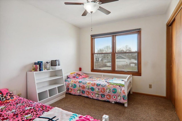 carpeted bedroom featuring ceiling fan and a closet