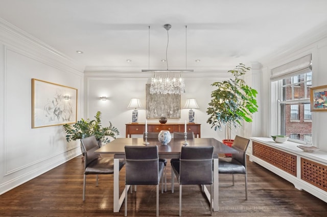 dining area with crown molding, baseboards, a notable chandelier, and wood finished floors