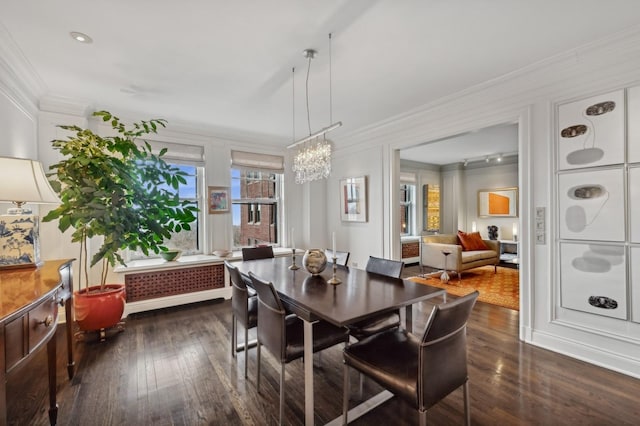 dining area with dark wood-style flooring, an inviting chandelier, and ornamental molding