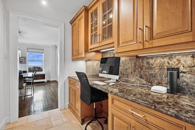 home office with built in desk, baseboards, and light tile patterned flooring