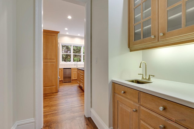 bar featuring sink, hardwood / wood-style floors, backsplash, and crown molding