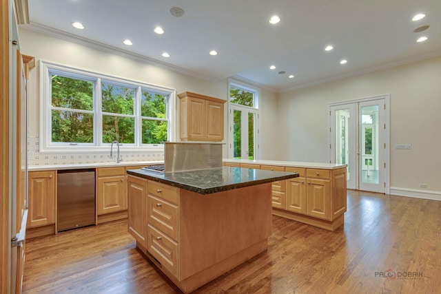 kitchen featuring light brown cabinetry, light hardwood / wood-style floors, tasteful backsplash, and a center island