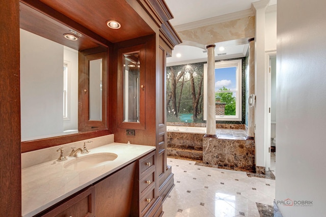 bathroom featuring ornamental molding, ornate columns, and vanity