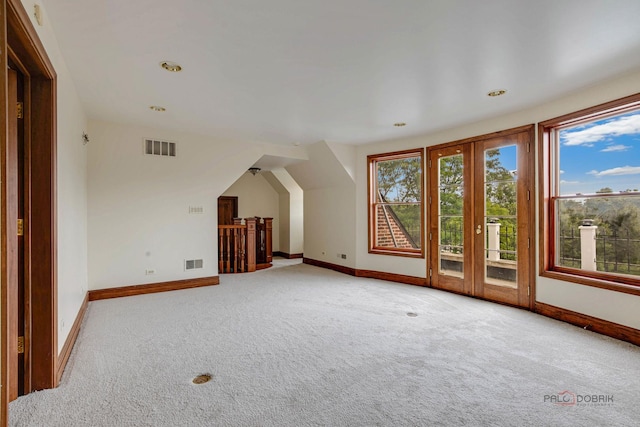 bonus room with french doors and light carpet