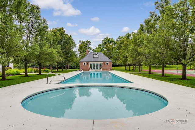 view of pool with a lawn